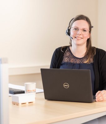 Anna Maria sitzt im Büro an Tisch mit PC